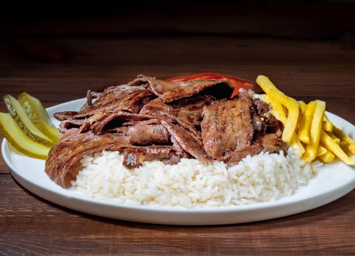 Pilav ve eşlikçileriyle servis edilen et döner